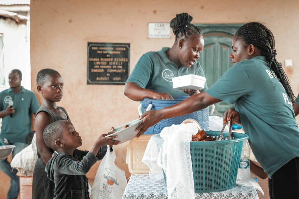 Volunteers sharing food packs with children
